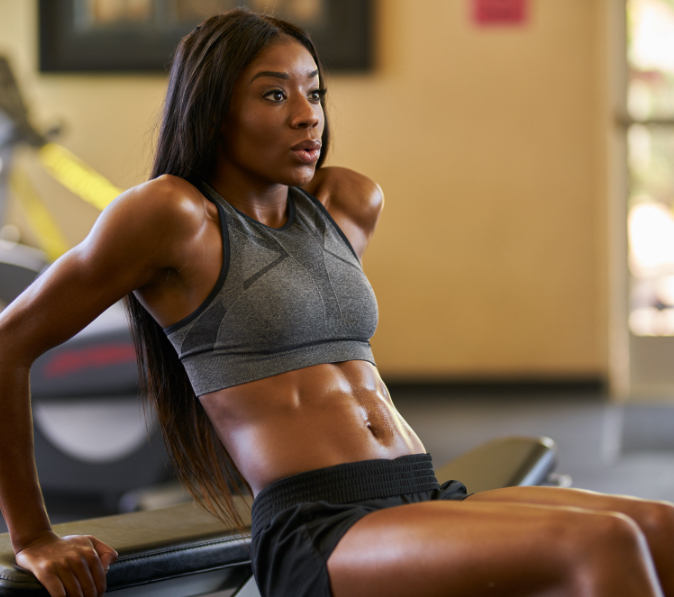 fit-african-american-woman-working-out-and-stretching-in-gym